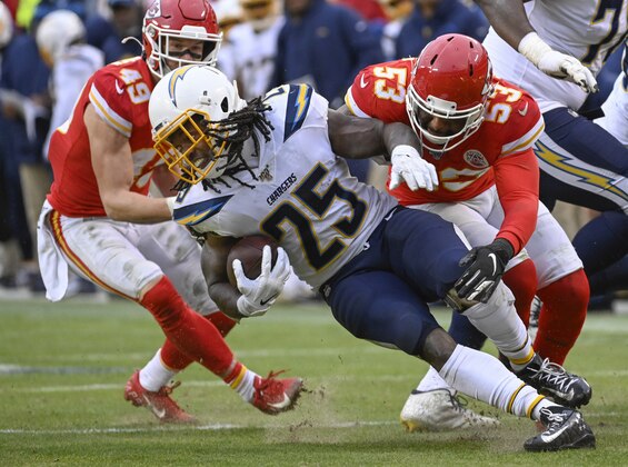 Los Angeles Chargers running back Melvin Gordon (25) is tackled by Kansas City Chiefs defensive back Daniel Sorensen (49) and Kansas City Chiefs inside linebacker Anthony Hitchens (53) during the second half of an NFL football game in Kansas City, Mo., Sunday, Dec. 29, 2019. (AP Photo/Reed Hoffmann)