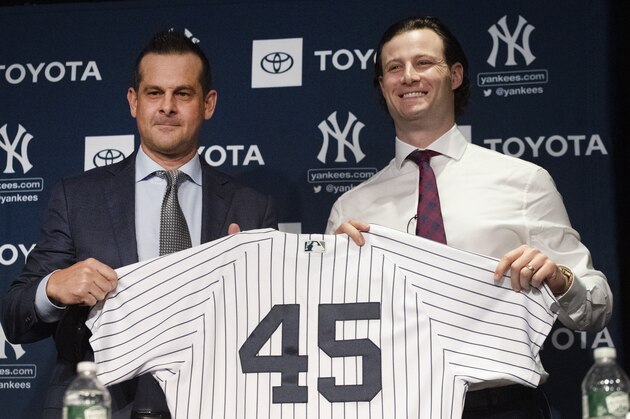 New York Yankees manager Aaron Boone, left, and pitcher Gerrit Cole hold up a jersey as Cole is introduced as the baseball club's newest player during a media availability, Wednesday, Dec. 18, 2019 in New York. The pitcher agreed to a 9-year, $324 million contract. (AP Photo/Mark Lennihan)