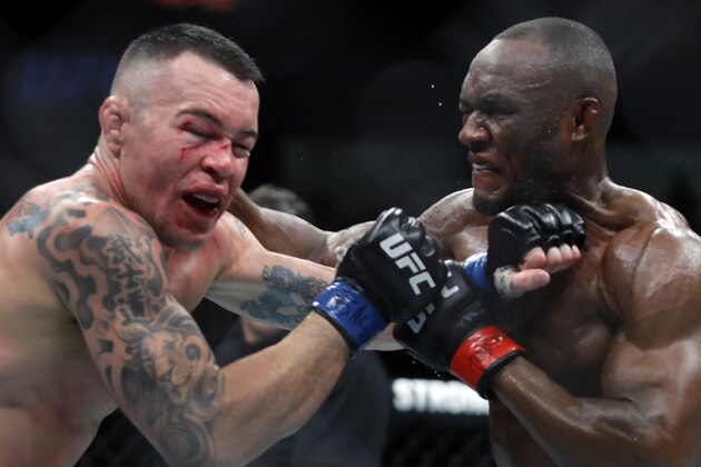 LAS VEGAS, NEVADA - DECEMBER 14:  Colby Covington (L) takes a punch from UFC welterweight champion Kamaru Usman in their welterweight title fight during UFC 245 at T-Mobile Arena on December 14, 2019 in Las Vegas, Nevada. Usman retained his title with a fifth-round TKO.  (Photo by Steve Marcus/Getty Images)