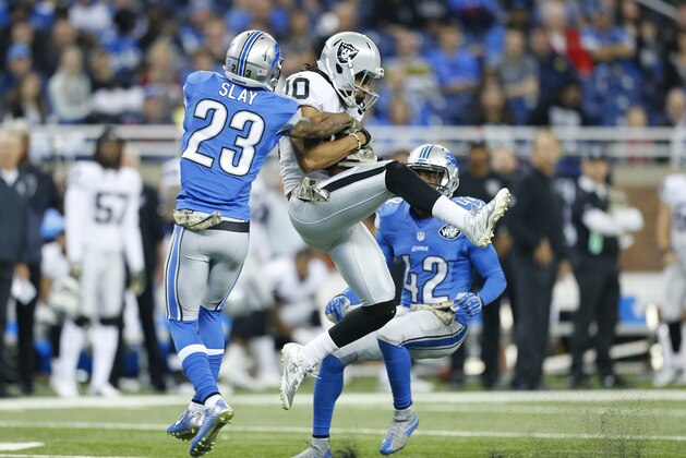 Oakland Raiders wide receiver Seth Roberts (10) catches a pass while defended by Detroit Lions cornerback Darius Slay (23) and strong safety Isa Abdul-Quddus (42) during the second half of an NFL football game, Sunday, Nov. 22, 2015, in Detroit. (AP Photo/Rick Osentoski)