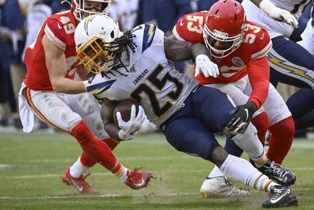 Los Angeles Chargers running back Melvin Gordon (25) is tackled by Kansas City Chiefs defensive back Daniel Sorensen (49) and Kansas City Chiefs inside linebacker Anthony Hitchens (53) during the second half of an NFL football game in Kansas City, Mo., Sunday, Dec. 29, 2019. (AP Photo/Reed Hoffmann)