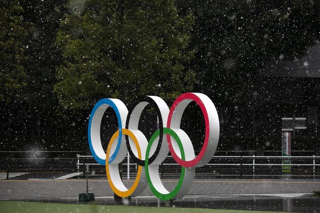 Snow falls on the Olympic rings near the New National Stadium in Tokyo, Saturday, March 14, 2020. (AP Photo/Jae C. Hong)