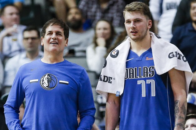 Dallas Mavericks owner Mark Cuban, left, and forward Luka Doncic (77) look on from the sidelines during the second half of an NBA basketball game against the Washington Wizards, Tuesday, Nov. 6, 2018, in Dallas. Dallas won 119-100. (AP Photo/Brandon Wade)