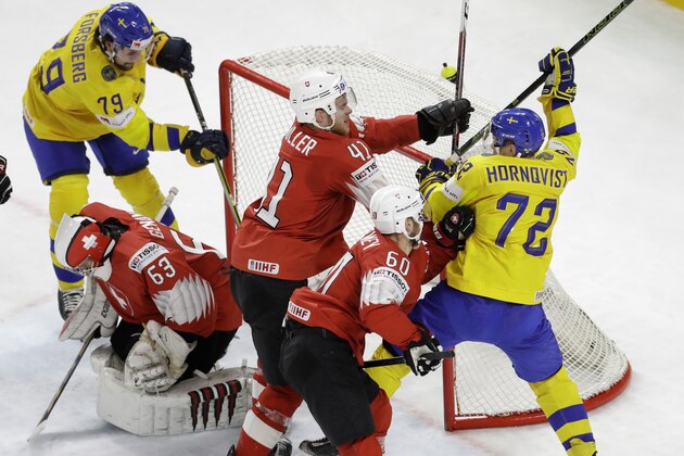 Switzerland's Mirco Muller, centre and Tristan Scherwey block Sweden's Patric Hornqvist, right, during the Ice Hockey World Championships final match between Sweden and Switzerland at the Royal arena in Copenhagen, Denmark, Sunday, May 20, 2018. (AP Photo/Petr David Josek)