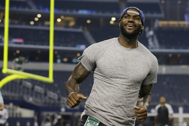 NBA basketball player LeBron James plays pick-up football on the Dallas Cowboys field after an NFL football game against the New York Giants, Sunday, Sept. 8, 2013, in Arlington, Texas. The Cowboys won 36-31. (AP Photo/Tony Gutierrez)