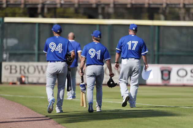 Members of the Toronto Blue Jays leave the field after a spring training baseball game against the Pittsburgh Pirates, Thursday, March 12, 2020, in Bradenton, Fla. (AP Photo/Carlos Osorio)