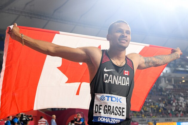 Canada's Andre De Grasse celebrates with the national flag after finishing third in the Men's 100m final at the 2019 IAAF World Athletics Championships at the Khalifa International stadium in Doha on September 28, 2019. (Photo by Kirill KUDRYAVTSEV / AFP) (Photo by KIRILL KUDRYAVTSEV/AFP via Getty Images)