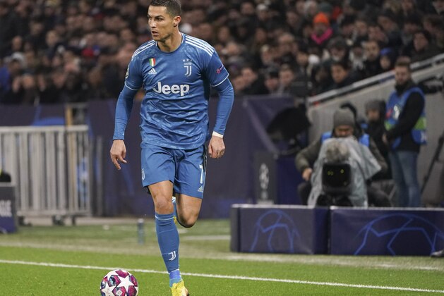 Juventus' Cristiano Ronaldo runs with the ball during a round of sixteen, first leg, soccer match between Lyon and Juventus at the at the Lyon Olympic Stadium in Decines, outside Lyon, France, Wednesday, Feb. 26, 2020. (AP Photo/Laurent Cipriani)