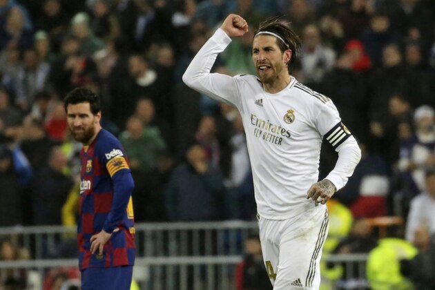 Real Madrid's Sergio Ramos celebrates as he runs past Barcelona's Lionel Messi during the Spanish La Liga soccer match between Real Madrid and Barcelona at the Santiago Bernabeu stadium in Madrid, Spain, Sunday, March 1, 2020. (AP Photo/Andrea Comas)