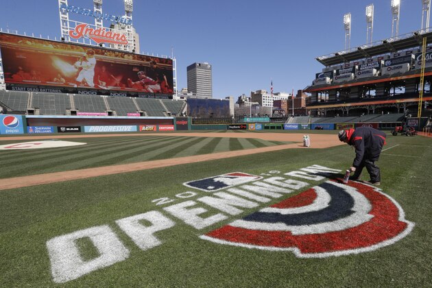 Mathew Gudin paints the opening day signage on the field before the Cleveland Indians play the Chicago White Sox in a baseball game, Monday, April 1, 2019, in Cleveland. (AP Photo/Tony Dejak)