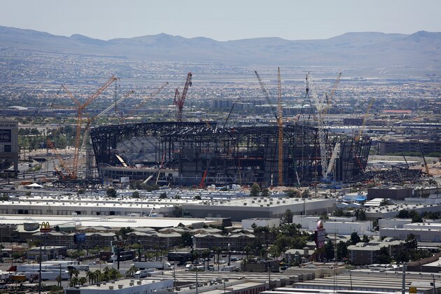 FILE - In this June 4, 2019, file photo, construction cranes surround the football stadium under construction in Las Vegas. Officials say installation of a translucent roof is behind schedule on the $2 billion football stadium being built in Las Vegas for the relocated NFL Raiders. The Las Vegas Review-Journal reports that Raiders team and construction officials are expected to provide an update on Thursday, Jan. 16, 2020. to the Las Vegas Stadium Authority about the cover for 65,000-seat indoor Allegiant Stadium. Team officials say the stadium is still on track to open July 31, in time to host a first scheduled event Aug. 16. (AP Photo/John Locher, File)