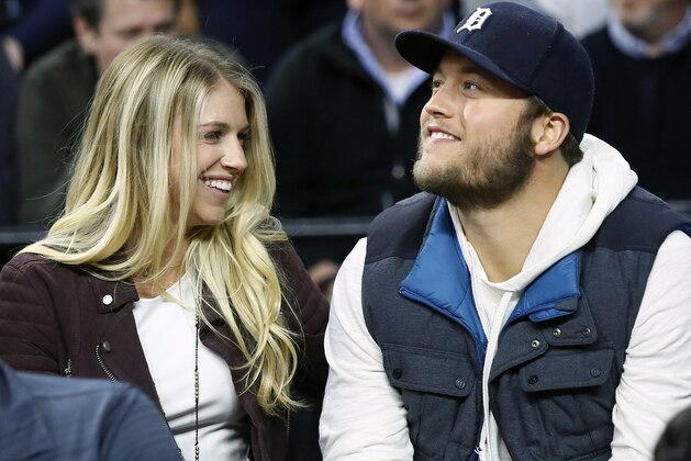 FILE - In this Nov. 17, 2015, file photo, Detroit Lions quarterback Matthew Stafford and his wife Kelly smile while watching the Detroit Pistons play the Cleveland Cavaliers during an NBA basketball game, in Auburn Hills, Mich. Matthew is juggling his job on the field and his role as a husband and father as his wife, Kelly, recovers from surgery to remove a brain tumor. (AP Photo/Duane Burleson, File)