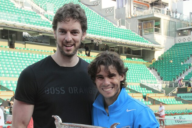 Spain's Rafael Nadal (R) poses with his trophy near US basketball player Pau Gasol  after winning his men's final in the French Open tennis championship at the Roland Garros stadium, on June 5, 2011, in Paris. Nadal won the final against Switzerland's Roger Federer.   AFP PHOTO / JACQUES DEMARTHON (Photo credit should read JACQUES DEMARTHON/AFP via Getty Images)