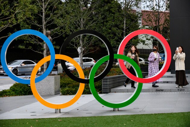 People take pictures of the Olympic Rings outside the closed Japan Olympic Museum in Tokyo on March 27, 2020, three days after the historic decision to postpone the 2020 Tokyo Olympic Games. (Photo by Philip FONG / AFP) (Photo by PHILIP FONG/AFP via Getty Images)