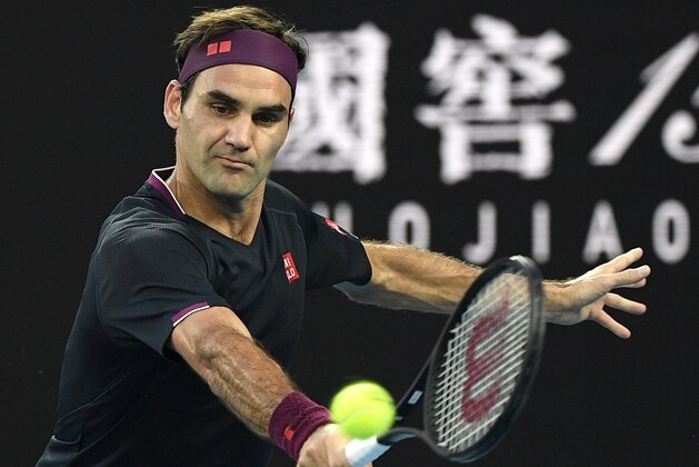 Switzerland's Roger Federer makes a backhand return to Serbia's Novak Djokovic during their semifinal match at the Australian Open tennis championship in Melbourne, Australia, Thursday, Jan. 30, 2020. (AP Photo/Andy Brownbill)