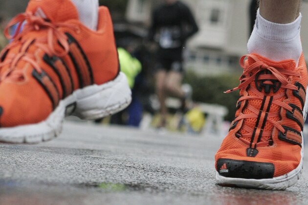 A timing chip is attached to shoe laces, right, of a runner in the Boston Marathon, Monday, April 16, 2007, in Newton, Mass. A radio transmitter inside the chips send each runner's ID number to an antenna, which routes the information to a central database.  (AP Photo/Mary Schwalm)