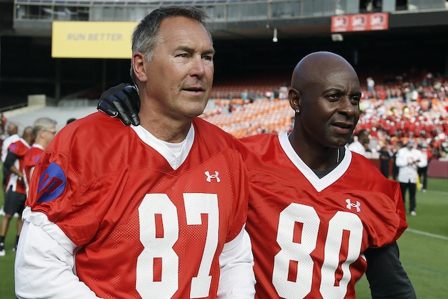 FILE - In this July 12, 2014, file photo, former San Francisco 49ers wide receivers Dwight Clark, left, and Jerry Rice, right, walk together on the field before the