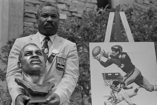 Former Cleveland Browns and Washington Redskins halfback and wide receiver Bobby Mitchell poses with his bronze bust after being inducted into the Pro Football Hall of Fame in ceremonies in Canton, Ohio, July 30, 1983.  (AP Photo/Gus Chan)