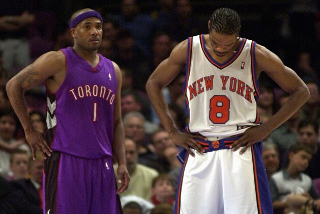 NEW YORK, UNITED STATES:  Latrell Sprewell (R)of the New York Knicks bows his head in the closing minutes of playoff game as Chris Childs (L) of the Toronto Raptors watches 04 May 2001 at Madison Square Garden in New York. The Raptors won the game 93-89 and the series, 3-2, and advance to the second round of the NBA playoffs.  AFP PHOTO/Stan HONDA (Photo credit should read STAN HONDA/AFP via Getty Images)
