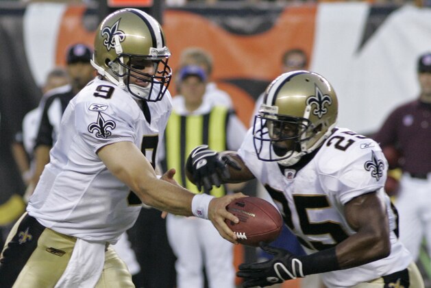 New Orleans Saints quarterback Drew Brees (9) hands off to running back Reggie Bush (25) in the first half of an NFL preseason football game against the Cincinnati Bengals, Saturday, Aug. 23, 2008, in Cincinnati. (AP Photo/Al Behrman)