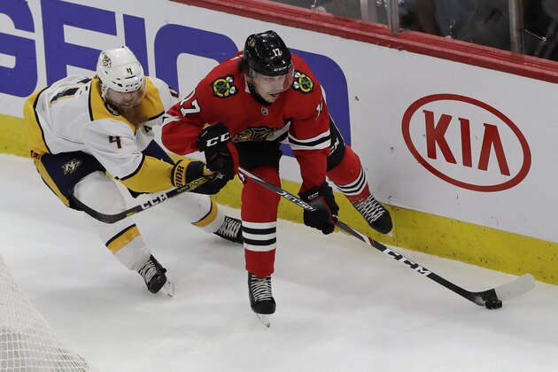 Chicago Blackhawks center Dylan Strome, right, looks to pass against Nashville Predators defenseman Ryan Ellis during the second period of an NHL hockey game in Chicago, Friday, Feb. 21, 2020. (AP Photo/Nam Y. Huh)