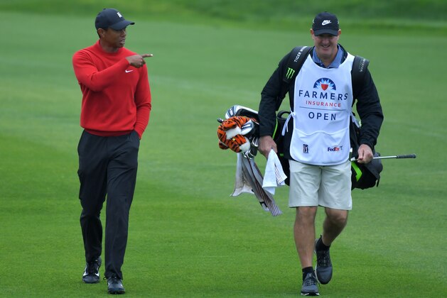 SAN DIEGO, CALIFORNIA - JANUARY 26: Tiger Woods and caddie Joe LaCava walk down the first fairway during the final round of the Farmers Insurance Open at Torrey Pines South on January 26, 2020 in San Diego, California. (Photo by Donald Miralle/Getty Images)