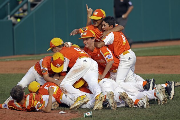 River Ridge, Louisiana's Stan Wiltz embraces Peyton Spadoni (6) as they jump on top of Jeffrey Curtis and Conner Perrot (9) on top of the pile as they celebrate the 8-0 win against Curacao in the Little League World Series Championship game in South Williamsport, Pa., Sunday, Aug. 25, 2019. (AP Photo/Tom E. Puskar)