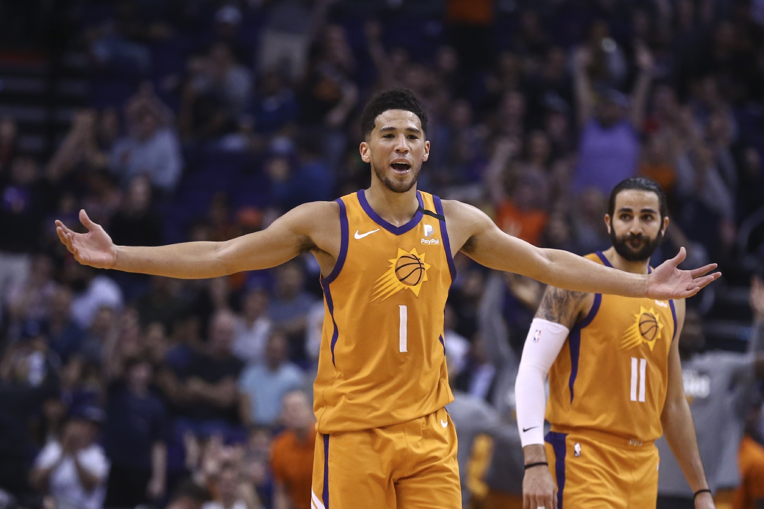Phoenix Suns guard Devin Booker (1) celebrates a 3-pointer against the Portland Trail Blazers by Suns' Aron Baynes, near guard Ricky Rubio (11) during the second half of an NBA basketball game Friday, March 6, 2020, in Phoenix. (AP Photo/Ross D. Franklin) Phoenix Suns guard Devin Booker (1) celebrates a 3-pointer against the Portland Trail Blazers by Suns' Aron Baynes, near guard Ricky Rubio (11) during the second half of an NBA basketball game Friday, March 6, 2020, in Phoenix. (AP Photo/Ross D. Franklin)
