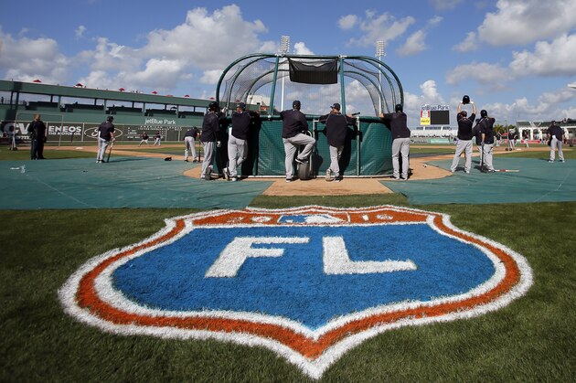 The Cactus League logo is shown at front as the New York Yankees take batting practice before a spring training baseball game against the Boston Red Sox on Tuesday, March 15, 2016, in Fort Myers, Fla. (AP Photo/Tony Gutierrez)