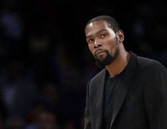 FILE- In this March 10, 2020, file photo, Brooklyn Nets' Kevin Durant watches during the second half of the team's NBA basketball game against the Los Angeles Lakers in Los Angeles. Durant is among the four Brooklyn Nets who have tested positive for the new coronavirus. (AP Photo/Marcio Jose Sanchez, file) FILE- In this March 10, 2020, file photo, Brooklyn Nets' Kevin Durant watches during the second half of the team's NBA basketball game against the Los Angeles Lakers in Los Angeles. Durant is among the four Brooklyn Nets who have tested positive for the new coronavirus. (AP Photo/Marcio Jose Sanchez, file)