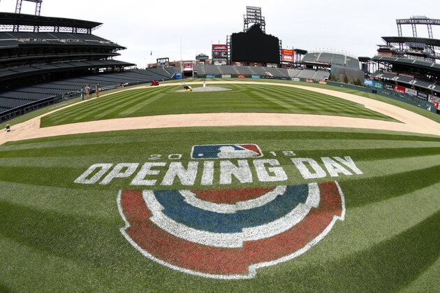 As viewed through a fisheye lens, a logo adorns the grass along the first-base line as grounds crew members prepare the field for the Colorado Rockies' regular-season home-opener Thursday, April 5, 2018, in Denver. A new scoreboard in left field is the highlight of work done in the off-season in Coors Field to mark the Rockies' 25th anniversary season. (AP Photo/David Zalubowski)