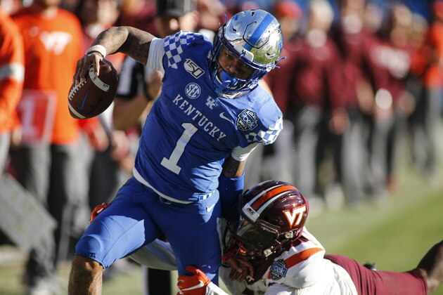 Kentucky quarterback Lynn Bowden Jr. (1) carries the football against Virginia Tech defensive back Reggie Floyd in the second half of the Belk Bowl NCAA college football game in Charlotte, N.C., Tuesday, Dec. 31, 2019. Kentucky won 37-30. (AP Photo/Nell Redmond)