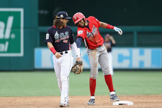 WASHINGTON, DC - JULY 15:  Fernando Tatis #23 of the San Diego Padres and the World Team (R) jokes with Bo Bichette #5 of the Toronto Blue Jays and the U.S. Team after stealing second base in the third inning against the U.S. Team during the SiriusXM All-Star Futures Game at Nationals Park on July 15, 2018 in Washington, DC.  (Photo by Rob Carr/Getty Images)