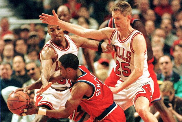 CHICAGO, UNITED STATES:  Rod Strickland (C) of the Washington Bullets falls in front of Scottie Pippen (L) and Steve Kerr (R) of the Chicago Bulls 27 April during the first half of game two of their first round playoff game at the United Center in Chicago, IL.     AFP PHOTO  Jeff HAYNES (Photo credit should read JEFF HAYNES/AFP via Getty Images)