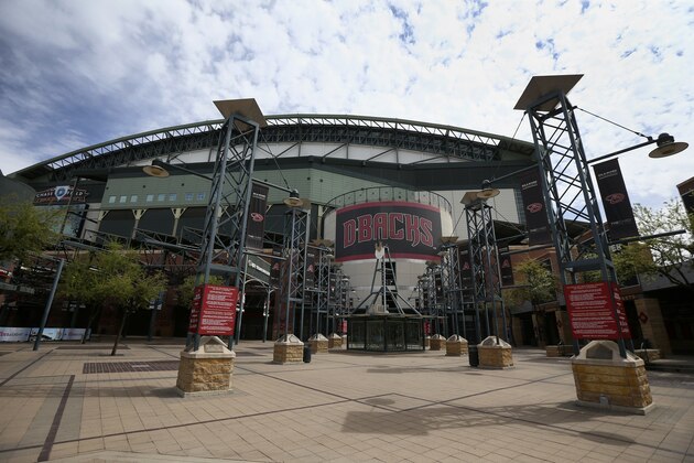 FILE - In this Thursday, March 26, 2020 file photo, The main entrance in front of Chase Field is devoid of activity in Phoenix. Putting all 30 teams in the Phoenix area this season and playing in empty ballparks was among the ideas discussed Monday, April 6, 2020 during a call among five top officials from MLB and the players' association that was led by Commissioner Rob Manfred, people familiar with the discussion told The Associated Press.  (AP Photo/Ross D. Franklin, File)