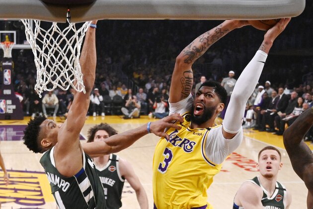 Los Angeles Lakers forward Anthony Davis, right, shoots as Milwaukee Bucks forward Giannis Antetokounmpo defends during the first half of an NBA basketball game Friday, March 6, 2020, in Los Angeles. (AP Photo/Mark J. Terrill)