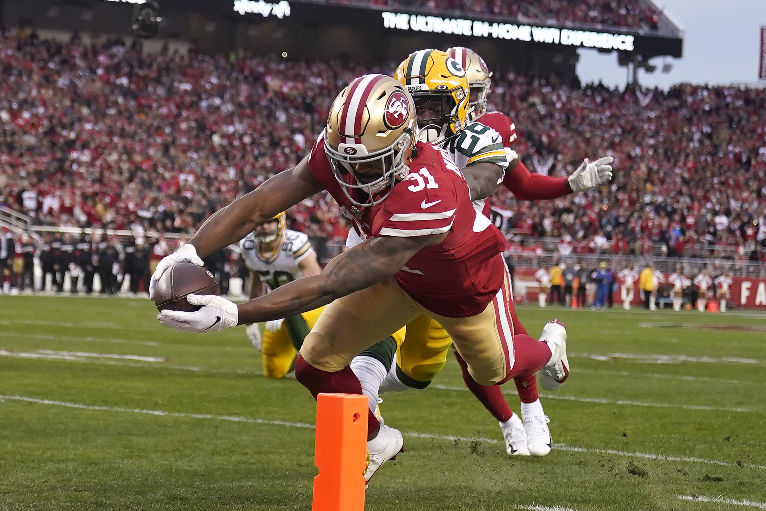 Raheem Mostert, corredor de los 49ers de San Francisco, anota frente a Darnell Savage, de los Packers de Green Bay, durante el encuentro por el tÃ­tulo de la Conferencia Nacional, el domingo 19 de enero de 2020 en Santa Clara, California (AP Foto/Tony Avelar)