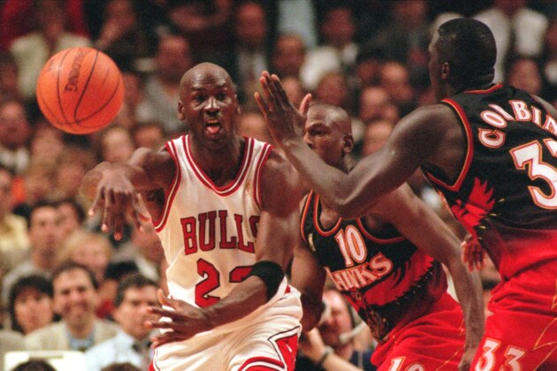 Chicago Bulls' Michael Jordan passes off around Atlanta Hawks' Mookie Blaylock (10) and Tyrone Corbin (33) during the second quarter of their playoff game Tuesday, May 6, 1997, in Chicago. (AP Photo/Fred Jewell)