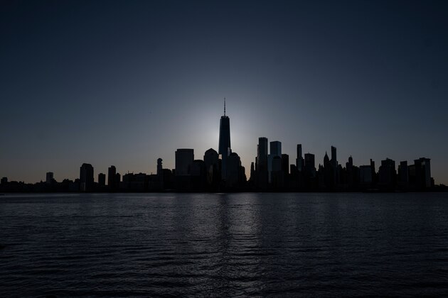The sun rises behind the skyline of Manhattan on April 11, 2020  in New York City. - The US overtook Italy on April to become the country with the largest death toll in the coronavirus pandemic, according to a tally kept by Johns Hopkins University. On april 10, the US reported 2,108 new deaths, the highest daily toll out of any country since the outbreak was first reported. (Photo by Johannes EISELE / AFP) (Photo by JOHANNES EISELE/AFP via Getty Images)
