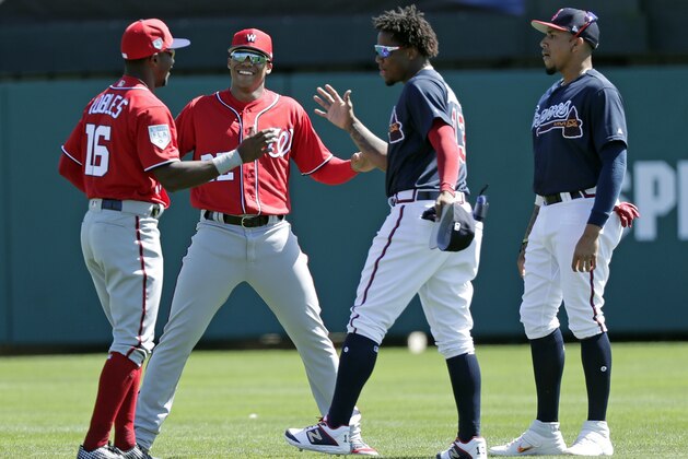 Washington Nationals' Victor Robles (16), and Juan Soto, second from left, greet Atlanta Braves' Ronald Acuna Jr., second from right, and Johan Camargo, right, before a spring baseball exhibition game, Monday, Feb. 25, 2019, in Kissimmee, Fla. (AP Photo/John Raoux)