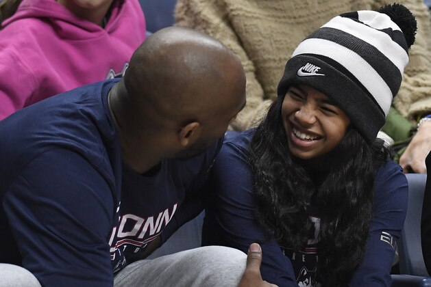 Kobe Bryant and his daughter Gianna watch the first half of an NCAA college basketball game between Connecticut and Houston, Saturday, March 2, 2019, in Storrs, Conn. (AP Photo/Jessica Hill)