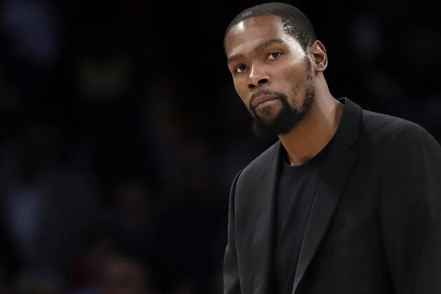 FILE- In this March 10, 2020, file photo, Brooklyn Nets' Kevin Durant watches during the second half of the team's NBA basketball game against the Los Angeles Lakers in Los Angeles. Durant is among the four Brooklyn Nets who have tested positive for the new coronavirus. (AP Photo/Marcio Jose Sanchez, file)