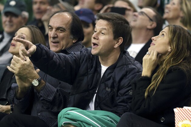 Actor Mark Wahlberg, center, sits courtside with his wife, Rhea Durham, right, during an NBA basketball game between the Boston Celtics and the Philadelphia 76ers in Boston, Saturday, Dec. 8, 2012. (AP Photo/Michael Dwyer)