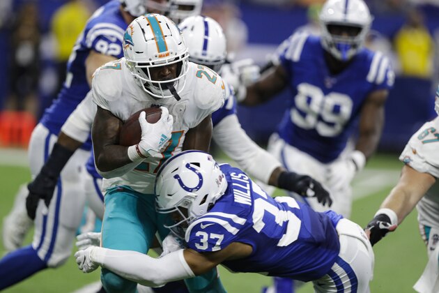 Miami Dolphins running back Kalen Ballage (27) is tackled by Indianapolis Colts safety Khari Willis (37) during the second half of an NFL football game in Indianapolis, Sunday, Nov. 10, 2019. (AP Photo/Darron Cummings)