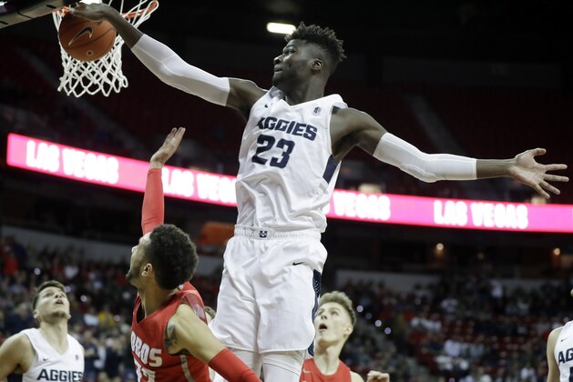 Utah State's Neemias Queta (23) blocks a shot from New Mexico's Anthony Mathis during the second half of an NCAA college basketball game in the Mountain West Conference men's tournament Thursday, March 14, 2019, in Las Vegas. (AP Photo/Isaac Brekken)