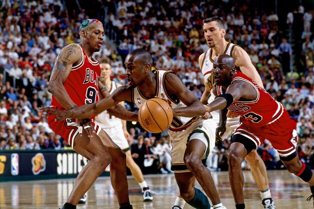 SEATTLE - JUNE 12:  Gary Payton #20 of the Seattle SuperSonics drives to the basket between Dennis Rodman #91 and Michael Jordan #23 of the Chicago Bulls in Game Four of the 1996 NBA Finals at Key Arena on June 12, 1996 in Seattle, Washington.  The Sonics won 107-86. NOTE TO USER: User expressly acknowledges that, by downloading and or using this photograph, User is consenting to the terms and conditions of the Getty Images License agreement. Mandatory Copyright Notice: Copyright 1996 NBAE (Photo by Andrew D. Bernstein/NBAE via Getty Images)