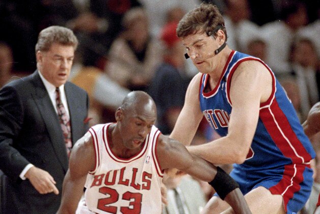 The Chicago Bulls' Michael Jordan (23) moves around the Detroit Pistons' Bill Laimbeer (40) during the first quarter of their playoff game in Chicago, May 21, 1991. Pistons coach Chuck Daly watches in the background. (AP Photo/John Swart)