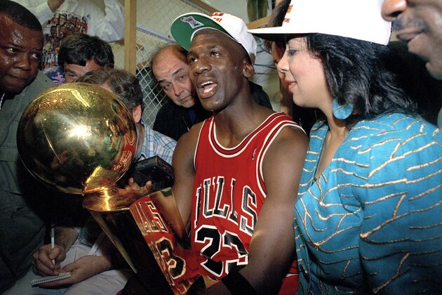 Chicago Bulls Michael Jordan holds the trophy after the Bulls 108-101 win over the Los Angeles Lakers in game five for the NBA championship in Inglewood, California, June 12, 1991. (AP Photo/Reed Saxon)