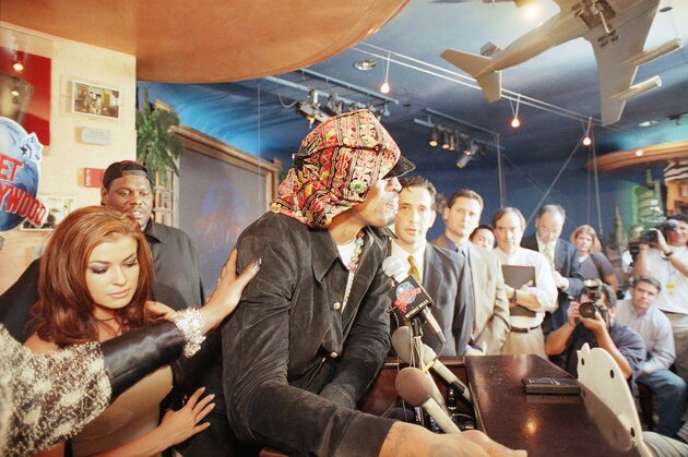 Dennis Rodman is comforted by his wife Carmen Electra, left, and an unidentified supporter as he breaks into tears amid skeptical questioning during a news conference in Beverly Hills, California on Monday, Feb. 22, 1999. The seven-time rebounding champion announced his intentions to sign with the Los Angeles Lakers but said there are still issues to be resolved. (AP Photo/John Hayes)