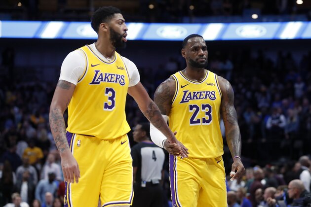Los Angeles Lakers' Anthony Davis (3) and LeBron James (23) celebrate as they walk back to the bench in the final seconds of overtime in the team's  NBA basketball game against the Dallas Mavericks in Dallas, Friday, Nov. 1, 2019. The Lakers won 119-110. (AP Photo/Tony Gutierrez)